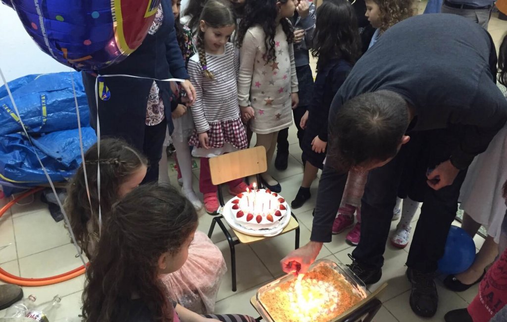 ילדים מסביב לעוגת יום הולדת