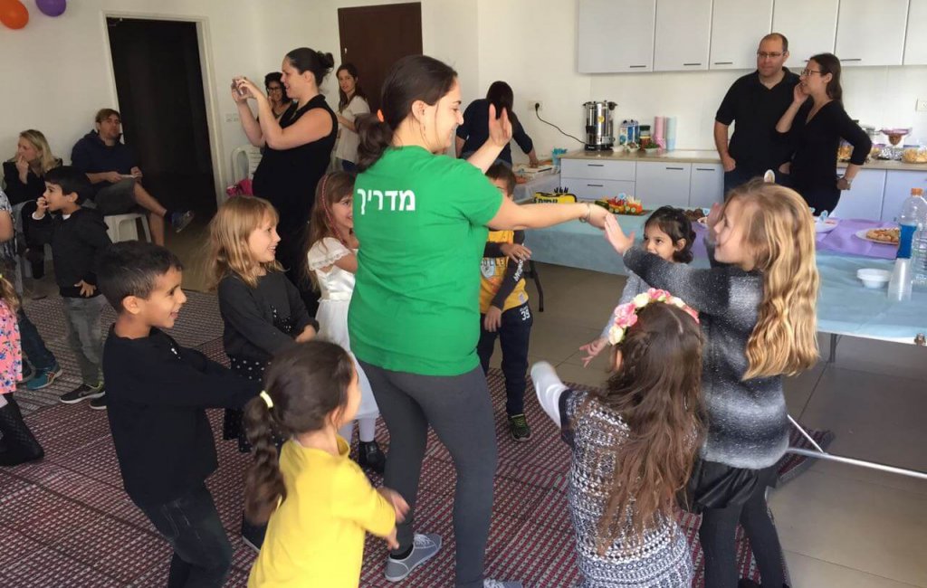 ילדים רוקדים עם המדריכים שלהם