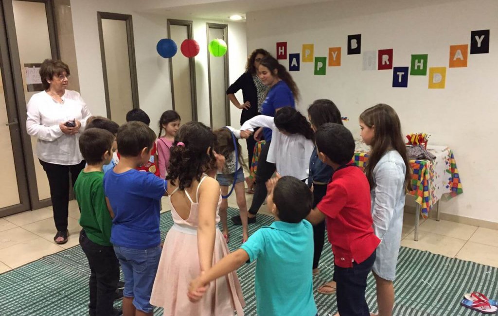 ילדים עומדים במעגל מחזיקים ידיים